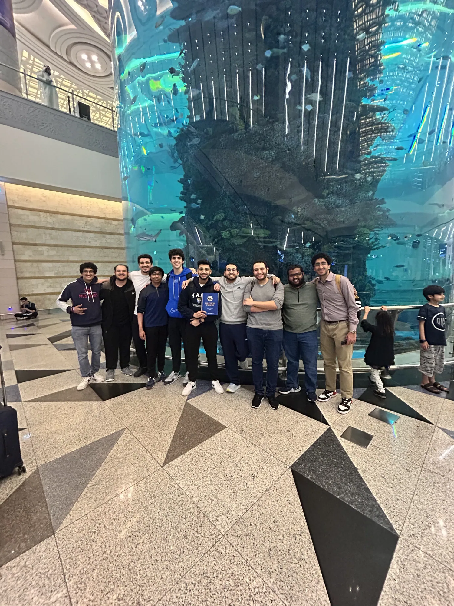 Students gathered with luggage at the airport after arriving in Jeddah.