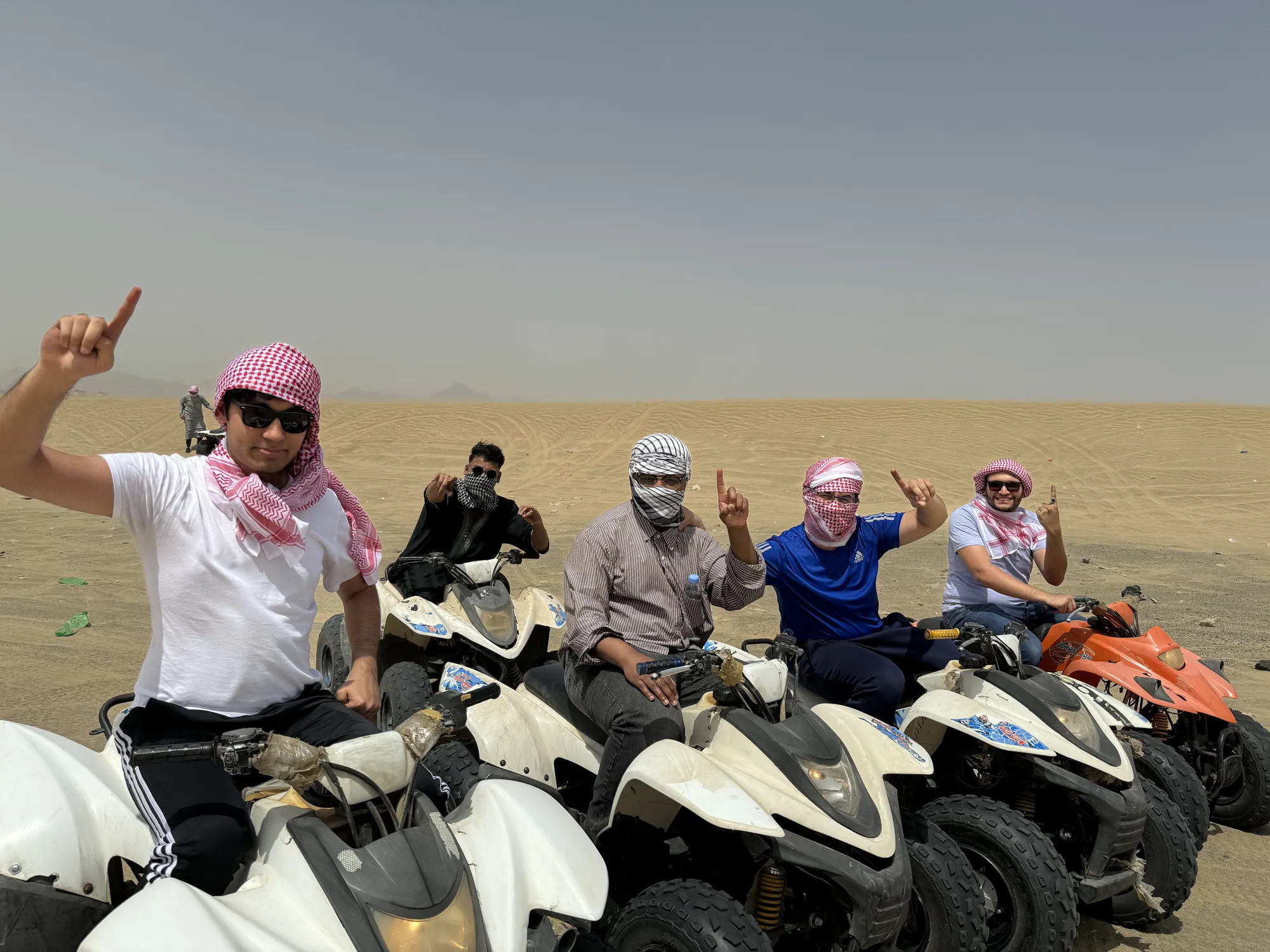 Students pausing together on all-terrain vehicles during a desert outing near Jeddah.