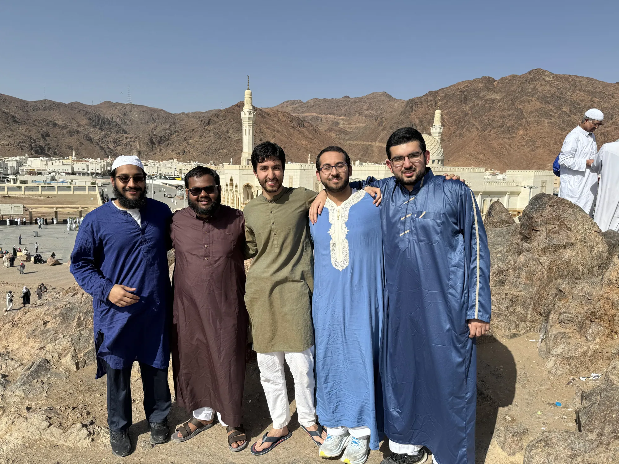 A group of students pausing together on the rocky slopes around Mount Uhud.