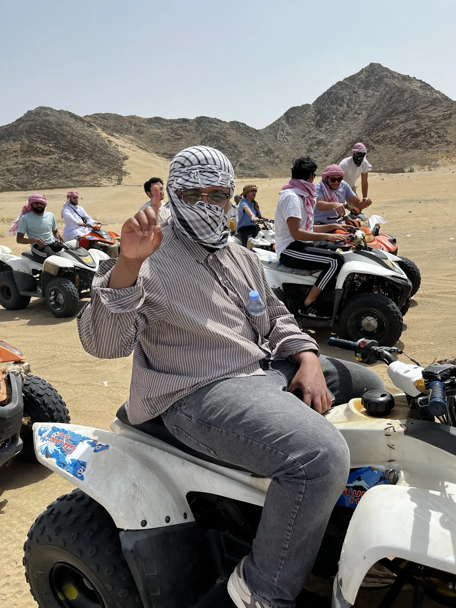 A student pausing on an all-terrain vehicle in the desert near Jeddah.